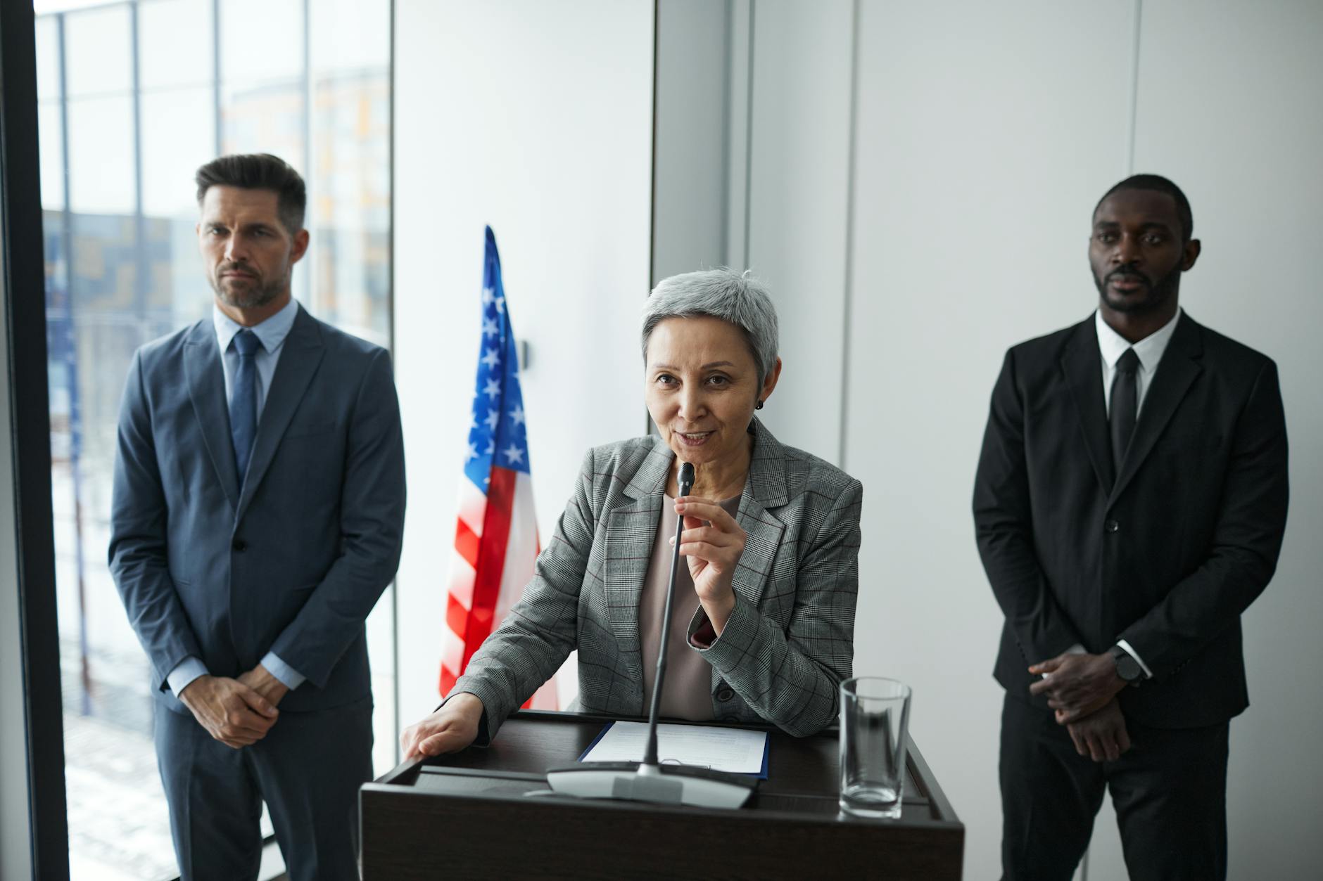 Polityczka przemawia na tle ochroniarzy i amerykańskiej flagi