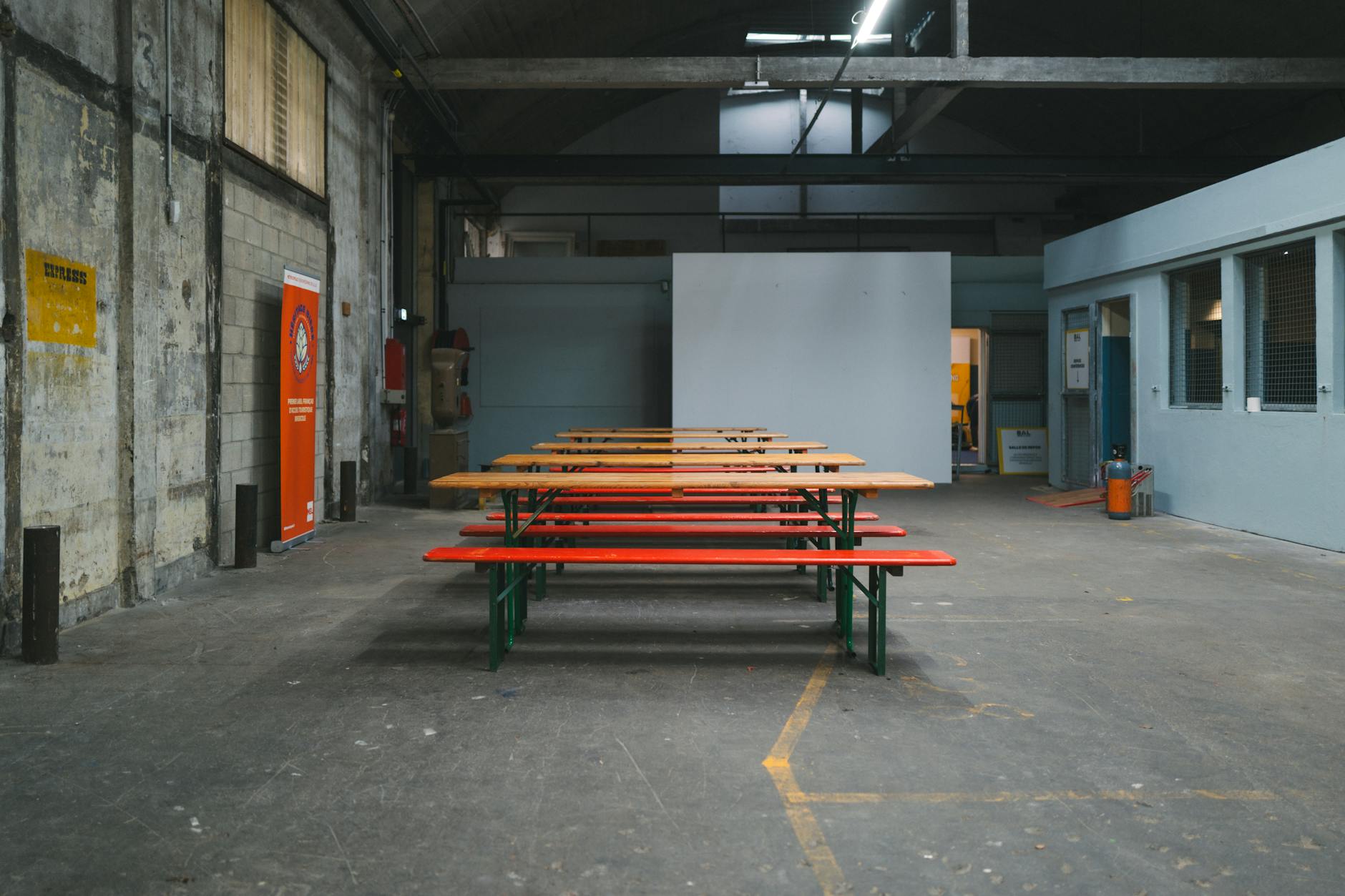 Pusta industrialna hala z drewnianymi ławkami przygotowana na spotkanie