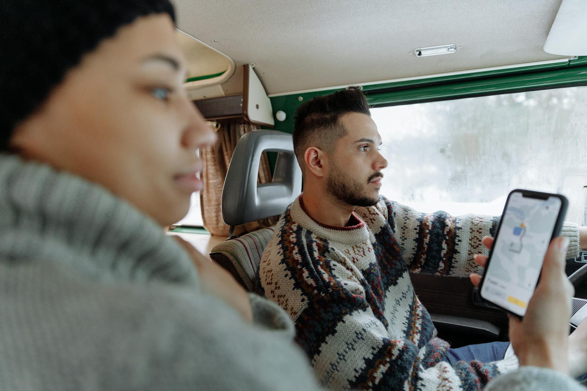 Para w retro kamperze planuje trasę w aplikacji nawigacyjnej