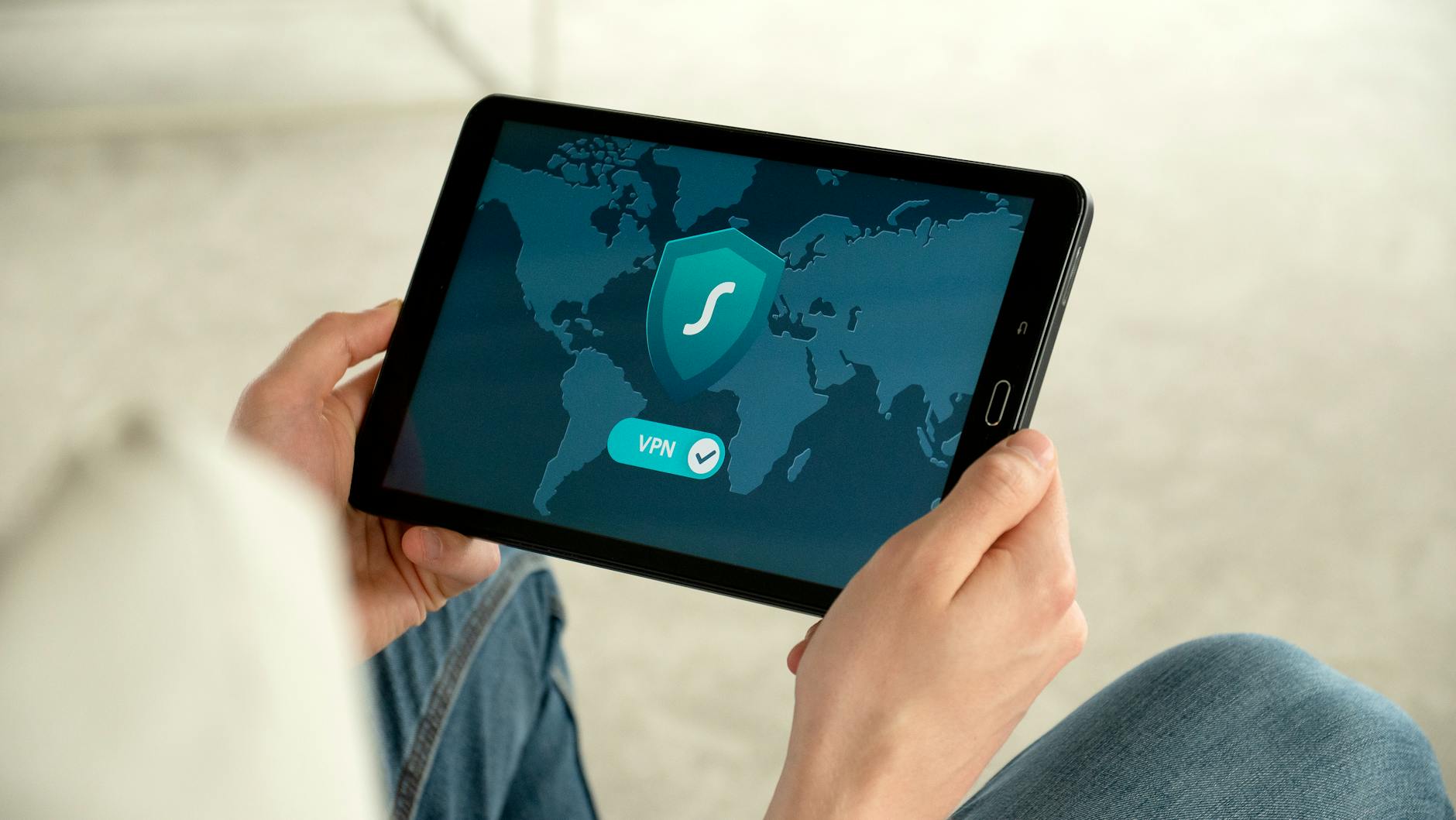Osoba trzyma tablet z ekranem połączenia VPN dla bezpiecznego internetu