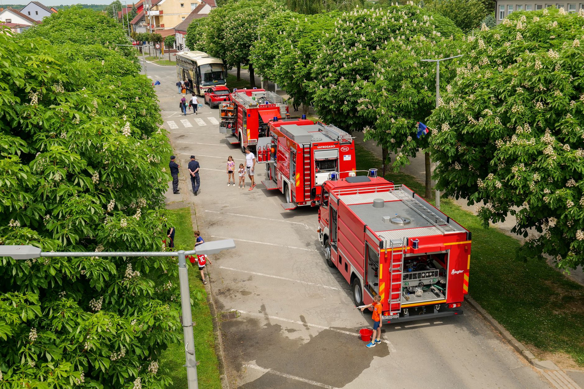 Jak zaplanować usługi publiczne w gminie sezonowej i turystycznej Wozy strażackie zaparkowane przy zacienionej drzewami ulicy